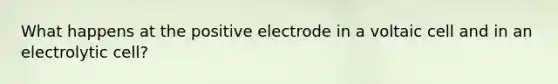 What happens at the positive electrode in a voltaic cell and in an electrolytic cell?