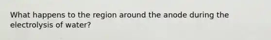 What happens to the region around the anode during the electrolysis of water?