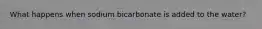 What happens when sodium bicarbonate is added to the water?