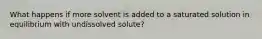 What happens if more solvent is added to a saturated solution in equilibrium with undissolved solute?