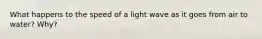 What happens to the speed of a light wave as it goes from air to water? Why?