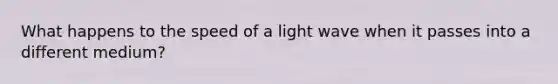 What happens to the speed of a light wave when it passes into a different medium?