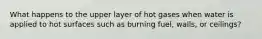 What happens to the upper layer of hot gases when water is applied to hot surfaces such as burning fuel, walls, or ceilings?