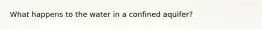 What happens to the water in a confined aquifer?