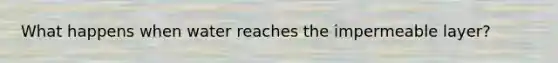 What happens when water reaches the impermeable layer?