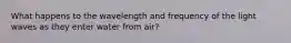 What happens to the wavelength and frequency of the light waves as they enter water from air?