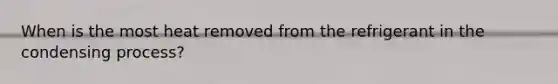 When is the most heat removed from the refrigerant in the condensing process?