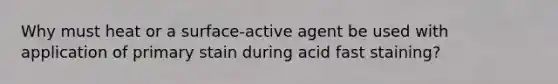 Why must heat or a surface-active agent be used with application of primary stain during acid fast staining?