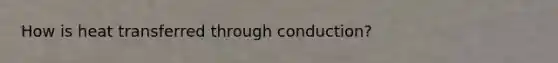 How is heat transferred through conduction?