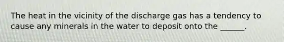 The heat in the vicinity of the discharge gas has a tendency to cause any minerals in the water to deposit onto the ______.