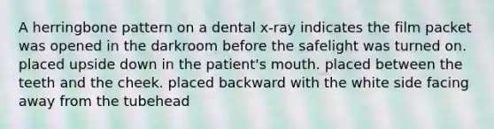 A herringbone pattern on a dental x-ray indicates the film packet was opened in the darkroom before the safelight was turned on. placed upside down in the patient's mouth. placed between the teeth and the cheek. placed backward with the white side facing away from the tubehead