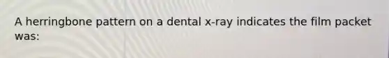 A herringbone pattern on a dental x-ray indicates the film packet was: