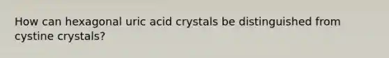 How can hexagonal uric acid crystals be distinguished from cystine crystals?