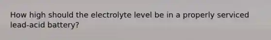 How high should the electrolyte level be in a properly serviced lead-acid battery?