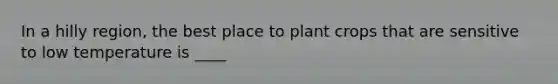 In a hilly region, the best place to plant crops that are sensitive to low temperature is ____