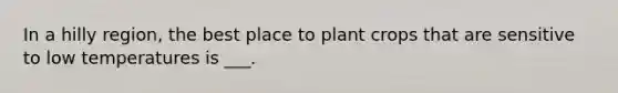 In a hilly region, the best place to plant crops that are sensitive to low temperatures is ___.