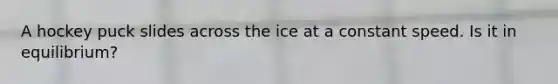 A hockey puck slides across the ice at a constant speed. Is it in equilibrium?