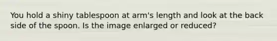 You hold a shiny tablespoon at arm's length and look at the back side of the spoon. Is the image enlarged or reduced?