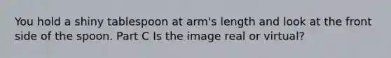 You hold a shiny tablespoon at arm's length and look at the front side of the spoon. Part C Is the image real or virtual?