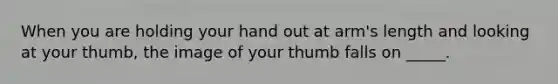 When you are holding your hand out at arm's length and looking at your thumb, the image of your thumb falls on _____.