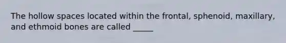 The hollow spaces located within the frontal, sphenoid, maxillary, and ethmoid bones are called _____