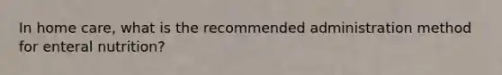 In home care, what is the recommended administration method for enteral nutrition?