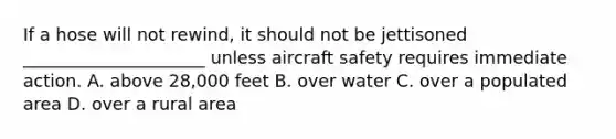 If a hose will not rewind, it should not be jettisoned _____________________ unless aircraft safety requires immediate action. A. above 28,000 feet B. over water C. over a populated area D. over a rural area