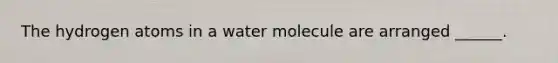 The hydrogen atoms in a water molecule are arranged ______.