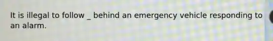 It is illegal to follow _ behind an emergency vehicle responding to an alarm.