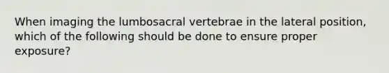 When imaging the lumbosacral vertebrae in the lateral position, which of the following should be done to ensure proper exposure?