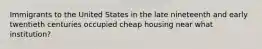 Immigrants to the United States in the late nineteenth and early twentieth centuries occupied cheap housing near what institution?