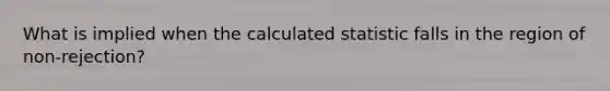 What is implied when the calculated statistic falls in the region of non-rejection?