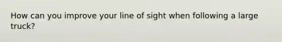 How can you improve your line of sight when following a large truck?