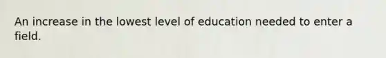 An increase in the lowest level of education needed to enter a field.