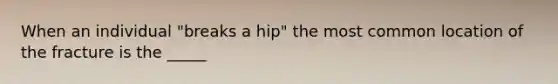 When an individual "breaks a hip" the most common location of the fracture is the _____