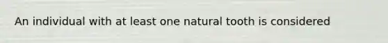 An individual with at least one natural tooth is considered