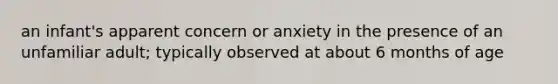 an infant's apparent concern or anxiety in the presence of an unfamiliar adult; typically observed at about 6 months of age