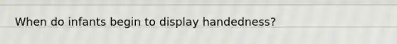 When do infants begin to display handedness?