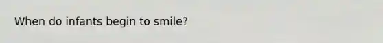 When do infants begin to smile?