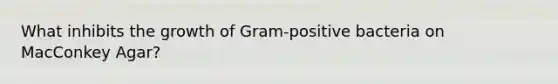 What inhibits the growth of Gram-positive bacteria on MacConkey Agar?