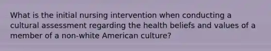 What is the initial nursing intervention when conducting a cultural assessment regarding the health beliefs and values of a member of a non-white American culture?