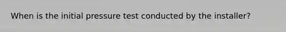 When is the initial pressure test conducted by the installer?