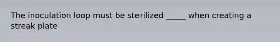 The inoculation loop must be sterilized _____ when creating a streak plate