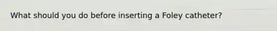 What should you do before inserting a Foley catheter?