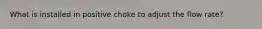 What is installed in positive choke to adjust the flow rate?