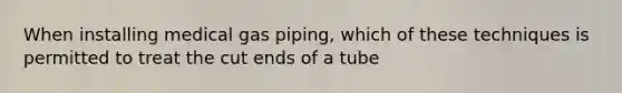 When installing medical gas piping, which of these techniques is permitted to treat the cut ends of a tube