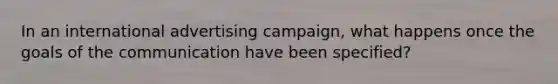 In an international advertising campaign, what happens once the goals of the communication have been specified?