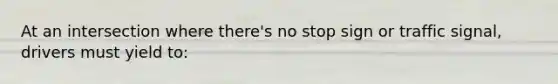 At an intersection where there's no stop sign or traffic signal, drivers must yield to: