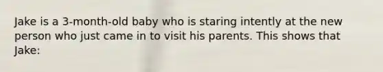 Jake is a 3-month-old baby who is staring intently at the new person who just came in to visit his parents. This shows that Jake: