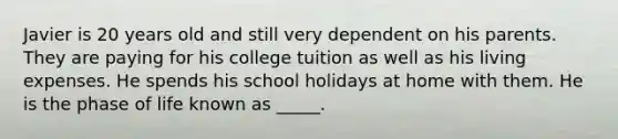 Javier is 20 years old and still very dependent on his parents. They are paying for his college tuition as well as his living expenses. He spends his school holidays at home with them. He is the phase of life known as _____.